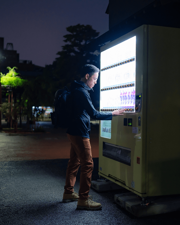 Person using a vending machine at night.