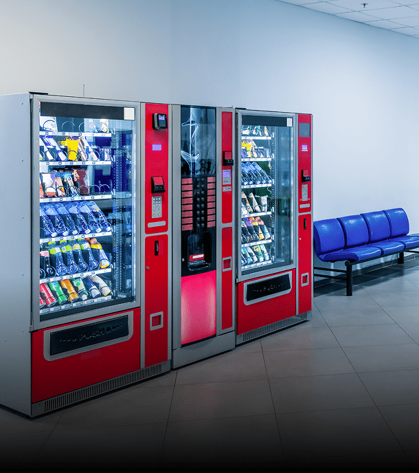 Red vending machines next to blue seats.